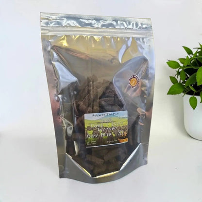 Irish Turf Peat Incense Wee Bits in a silver resealable bag beside a plant