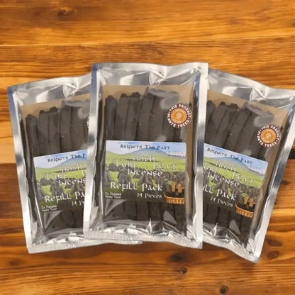 Three Irish Turf Peat Incense Refill Packs in silver foil bags on a wooden table