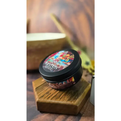 Nanny's Kitchen candle tin on a hexagon wooden stand, a mixing bowl behind
