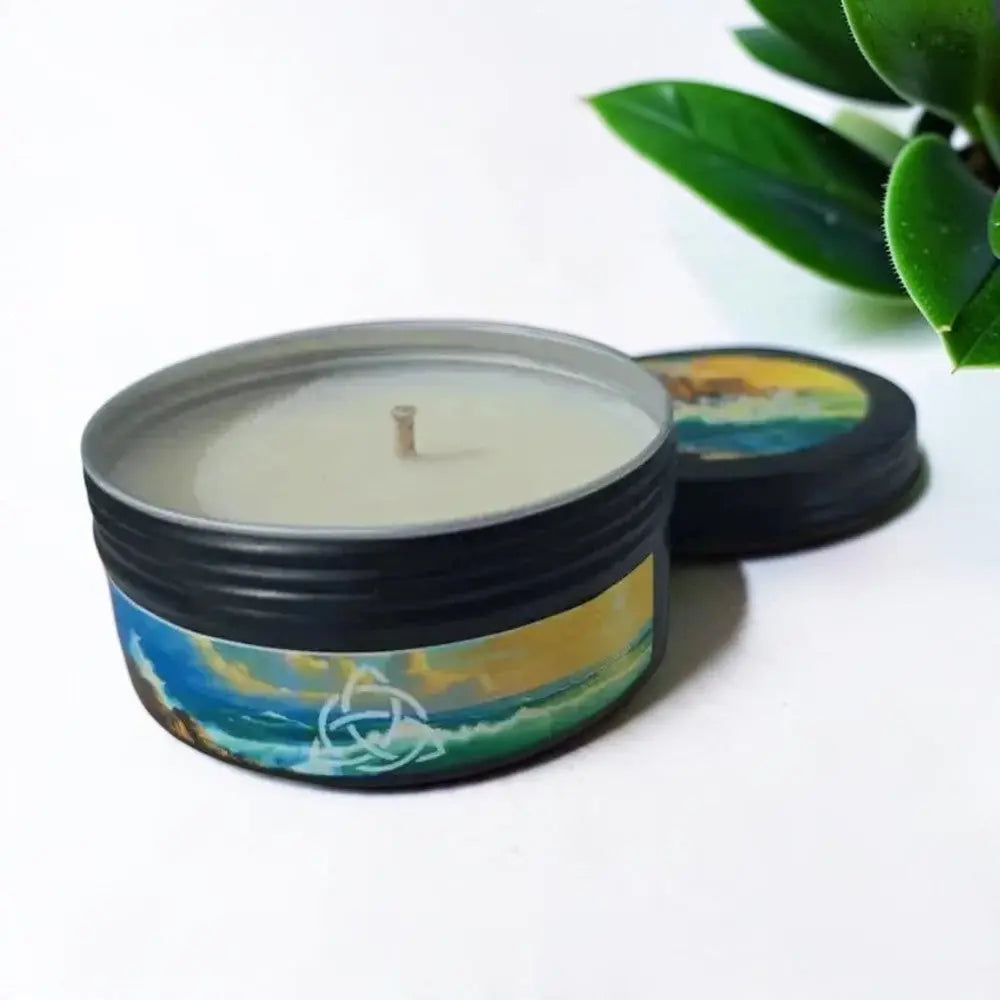 Wild Atlantic Way candle in a black tin with a seascape label, lid beside it